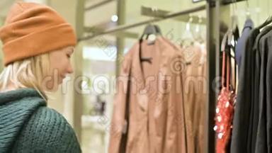 一个穿着绿色毛衣和黄色帽子的女孩穿过一家商店，选择买什么。 把事情搞得一团糟